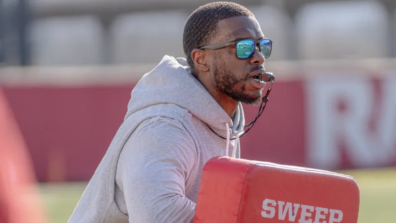 Razorbacks wide receivers coach Larry Smith after practice Monday