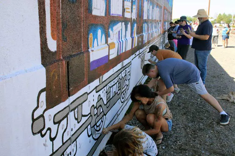 Dozens help with new mural at Safford Library