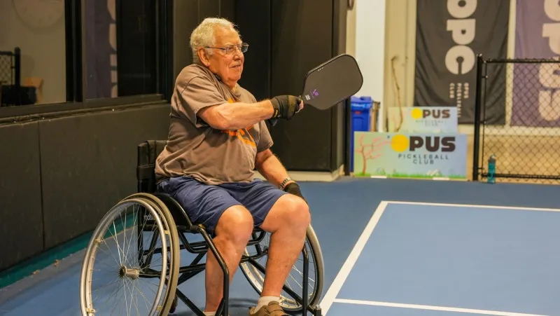 Wheelchair pickleball player swings his paddle with a purpose