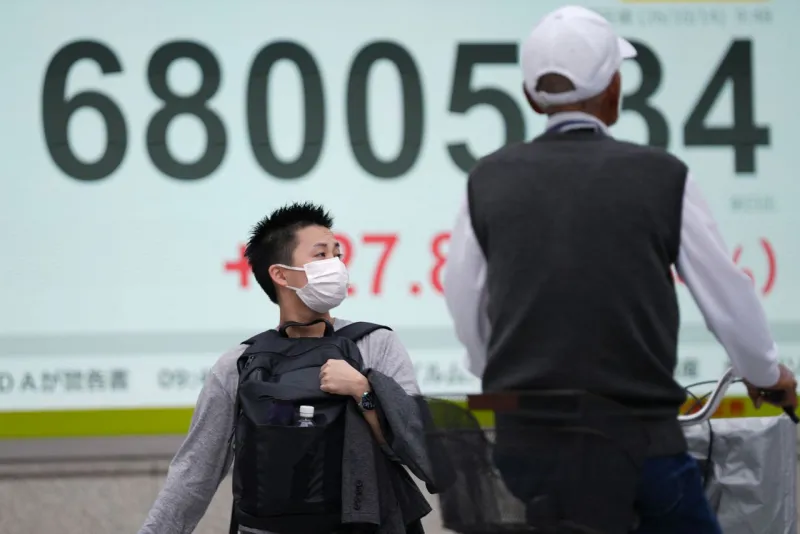Asian shares trade mixed after US stocks edge back from their record after profit reports