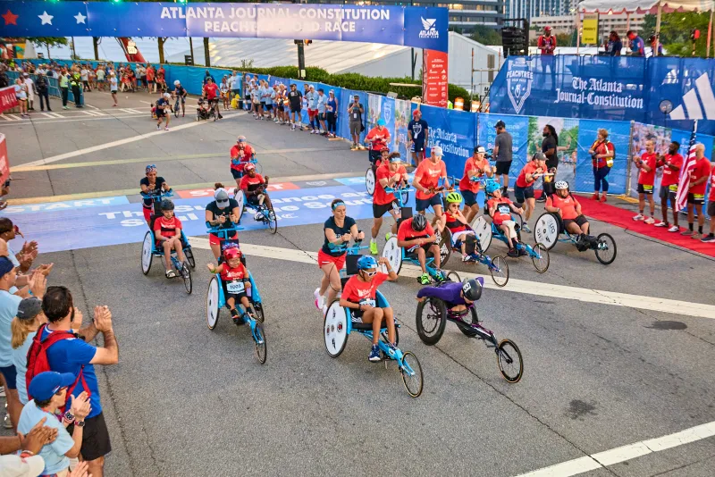 The Kyle Pease Foundation push teams tackle the heat, hills, and humidity at the Peachtree Road Race