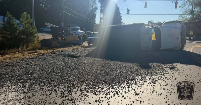 Dump truck overturns after van turns into its path