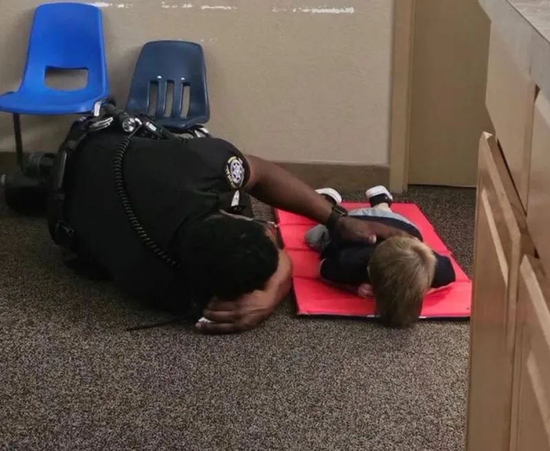 Emotional Photo Shows Local School Resource Officer on Floor With Child