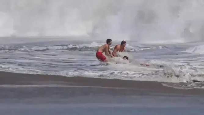 California lifeguard is hailed as a hero after rescuing a boy from pounding surf