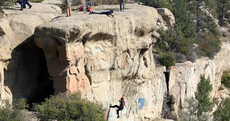 Photos: Firefighters rappel down Rimrocks to cover graffiti