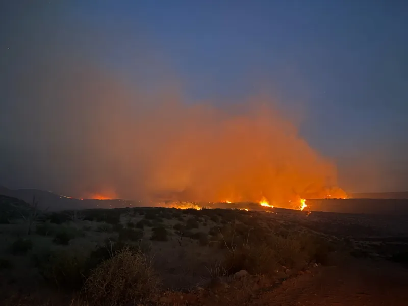 Firefighters battle dual wildfires in grasslands and rugged terrain near Caliente