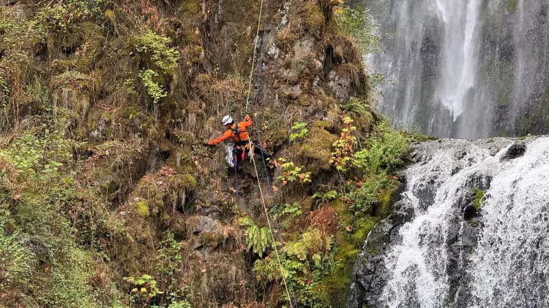Search and rescue volunteers clean up Multnomah Falls while training on ropes