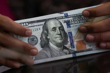 Dollar edges back from 18-month high after FOMC minutes