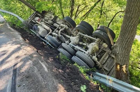 Coal Truck Overturns, Crashes Through Guardrail as Single Tree Stops Vehicle from Rolling Down Hillside